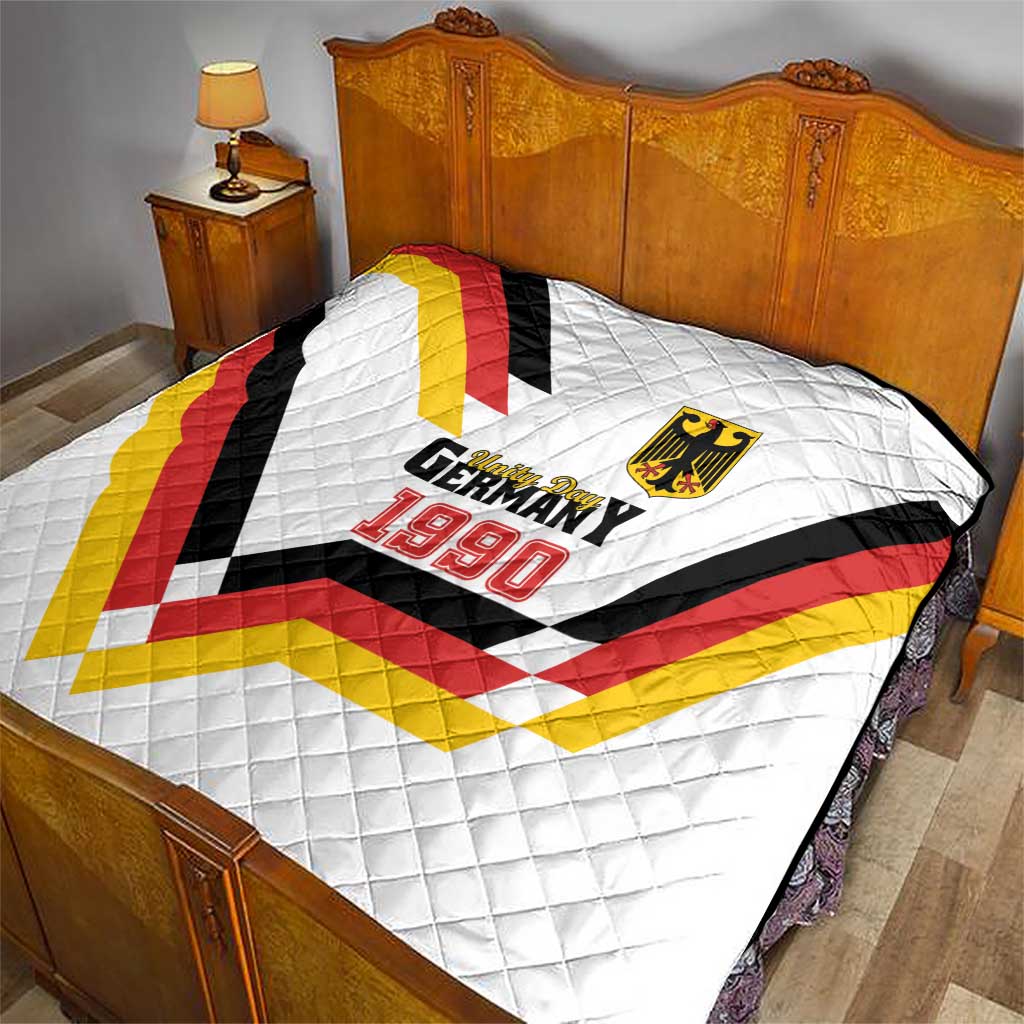White quilt on bed with Germany 1990 logo and crest over quilted V pattern