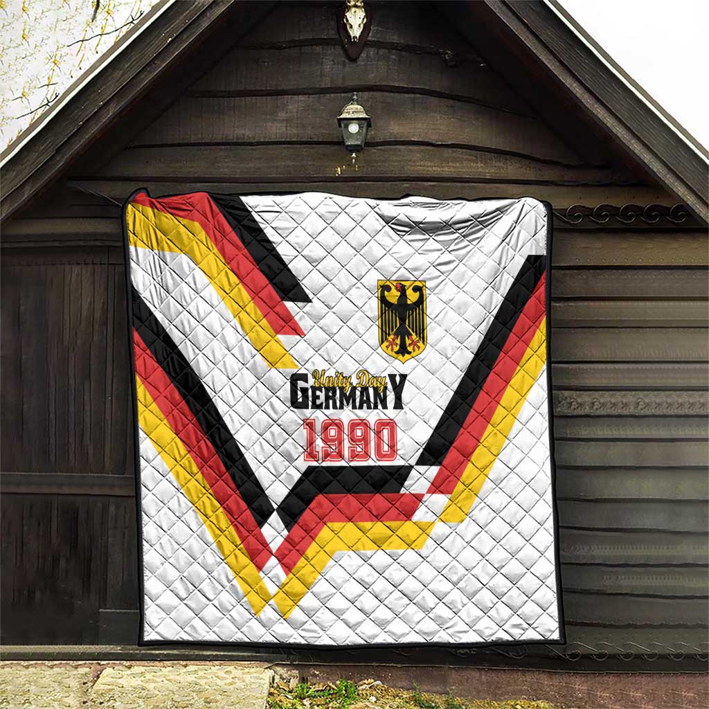 White quilt hanging on wall with Germany 1990 emblem and red-yellow-black chevrons
