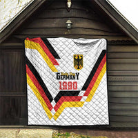 White quilt hanging on wall with Germany 1990 emblem and red-yellow-black chevrons