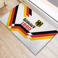White rubber doormat with Unity Day Germany 1990 logo and bold flag-style check bands