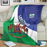 Lesotho-themed blanket with blue, white, and green flag art and coat of arms, draped over armchair