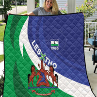 Flag quilt held up outdoors, green-white-blue diagonal stripes with 1966 coat-of-arms design