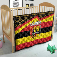 Uganda-themed quilt on wooden baby bed frame with black, yellow, red stripes and “UGANDA 09 October”
