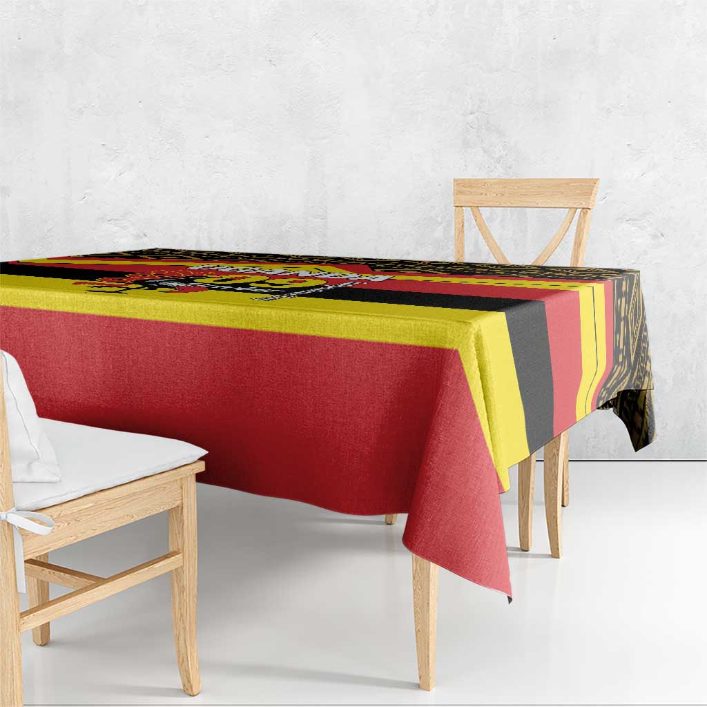 Printed tablecloth draped over table with red, yellow, and black Uganda flag-style pattern