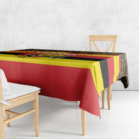 Printed tablecloth draped over table with red, yellow, and black Uganda flag-style pattern