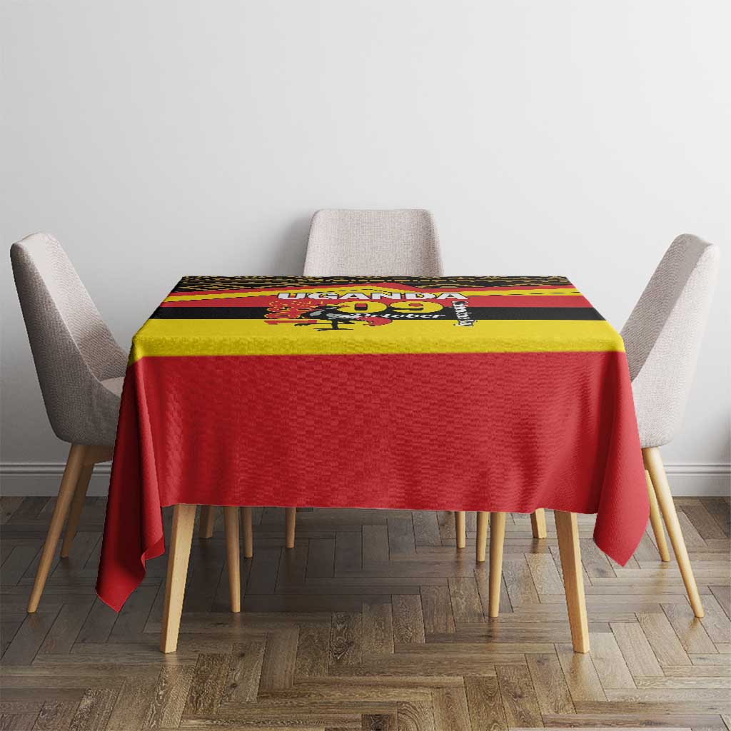 Printed tablecloth covering dining table, red base with yellow and black banded Uganda design