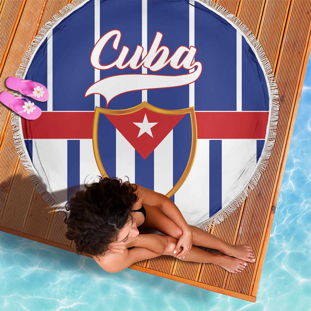 Round beach blanket with striped blue/white/red design, shield emblem, and fringe trim