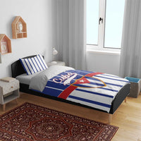 Blue striped Cuba bedding set styled on a bed with crest design on duvet