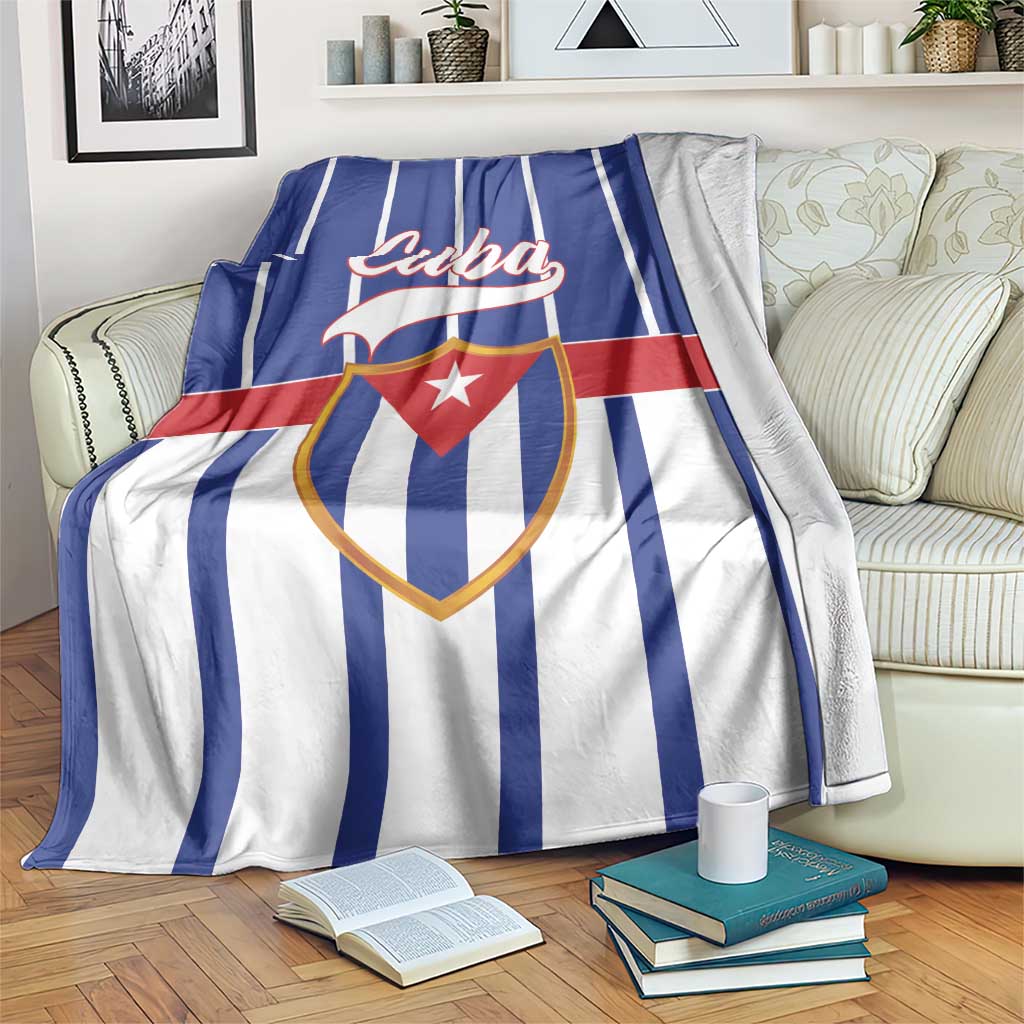 Cuba-themed blanket draped over couch with blue stripes, red band, shield with red star