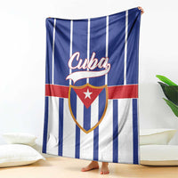 Cuba-themed blanket hanging with blue and white vertical stripes and red shield emblem
