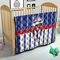 Cuba quilt blanket on wooden baby bed frame, blue-and-white stripes with red band and Cuban crest