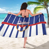 Blue and white striped sarong with red stripe and Cuba crest, worn as a wrap