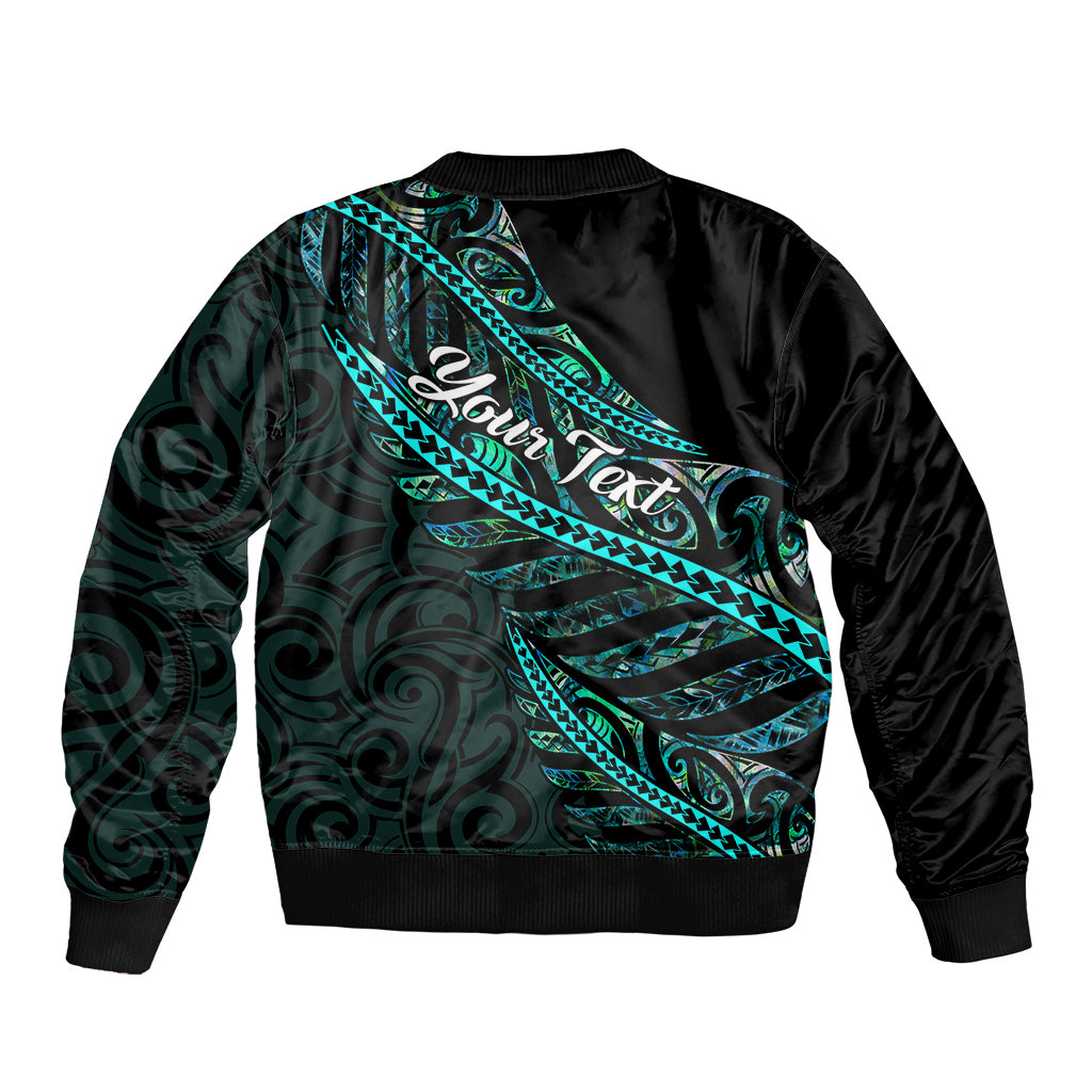 Black unisex bomber jacket with teal-green Polynesian back panel pattern, ribbed hem