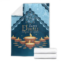 Blue Diwali festival blanket with 'Happy Diwali' diya print, shown folded with white rolls