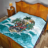 Blue quilt on a bed with tropical palm-and-skull “Aloha” artwork over waves