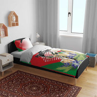 Bedding set on bed with red, green, and white gazelle graphic duvet and two pillows