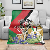 Palestine blanket spread on sofa, gazelle artwork with purple flowers and patterned gold
