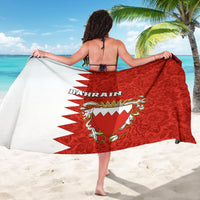 Red sarong worn with back panel showing Bahrain text and coat-of-arms crest