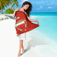 Red sarong with ornate crest design and white zigzag border