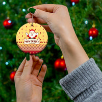 Yellow round ceramic Christmas ornament with Santa and "NEW JERSEY" text, held by hand