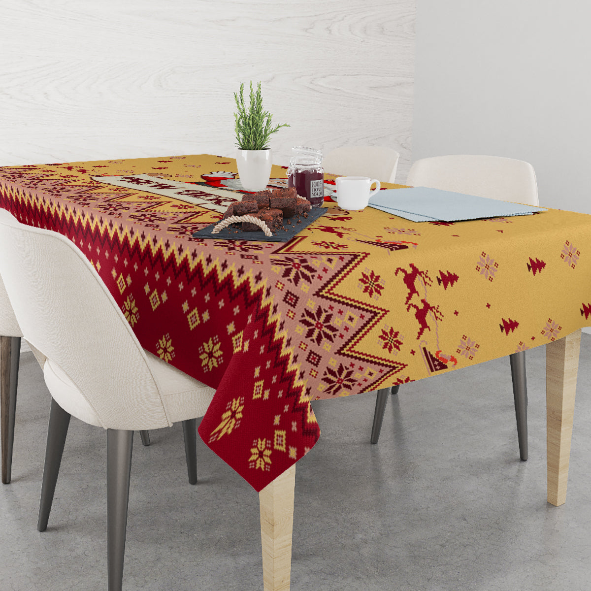 Christmas tablecloth covering table with gold-and-red border, reindeer and tree motifs