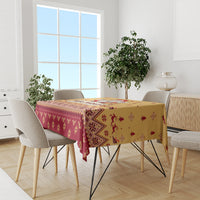 Christmas tablecloth on dining table with gold top, red pattern and Santa-themed motifs