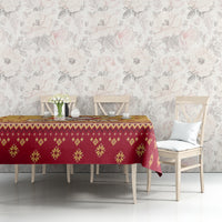 Christmas tablecloth with gold and red small motifs, draped over dining table