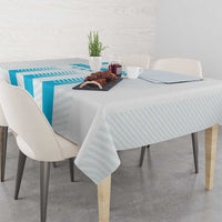 Blue striped tablecloth over dining table with centerpiece and drinkware