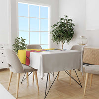 Yellow tablecloth with colorful rectangular graphic panel on round dining table.