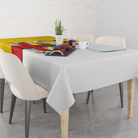 Gray tablecloth with colorful edge panel and small dining centerpiece on table.