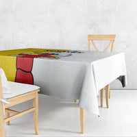 White tablecloth with colorful border and central graphic print draped over table.