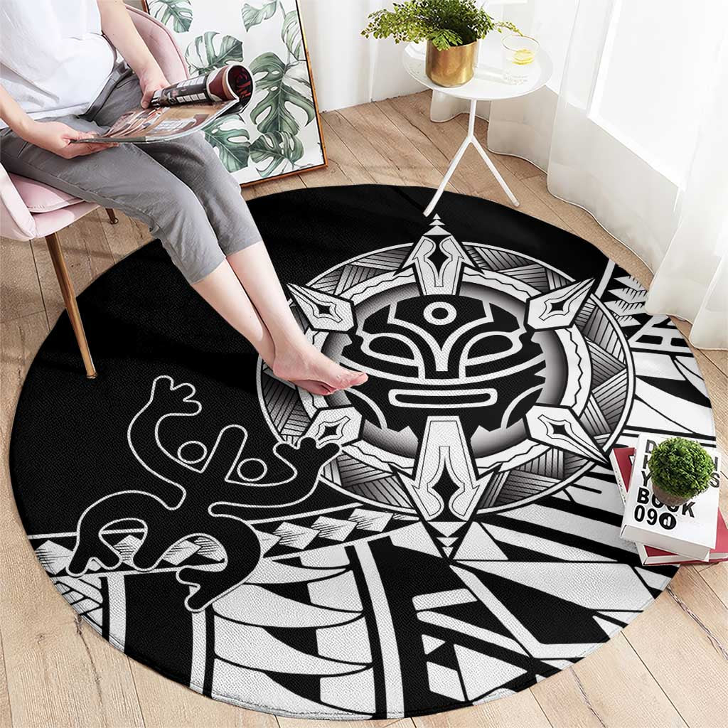 Black round area rug with white tribal mask, hand motifs, and radiating geometric lines