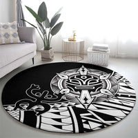 Black round area rug with white Polynesian tribal crest and bold symmetrical shapes