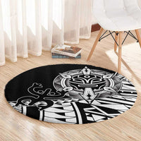 Black round area rug with white tribal mask and outlined Polynesian symbols