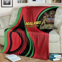 Malawi Independence Day blanket on bed, red base with green stripes and circular black emblem