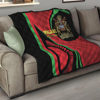 Folded black quilt with red and green Malawi emblem and quilted diamond texture