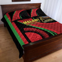Quilt bed set draped on bed edge in red, black, and green with Malawi Independence Day design
