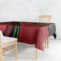 Black tablecloth draped over bench seating, showing Malawi Independence Day red and green print
