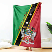 Green, black, and red Saint Kitts and Nevis blanket draped over seating with crest graphic