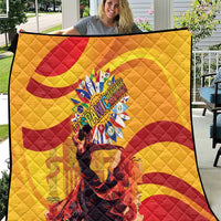Yellow quilt with red wave spirals and a central round emblem, close-up view