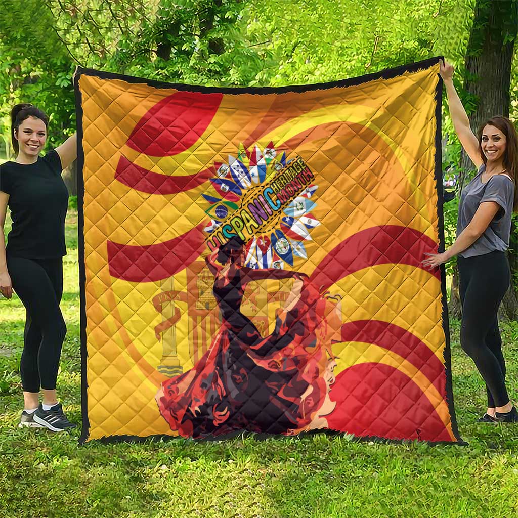 Yellow quilt with red spiral swirls and a central round emblem, spread on grass