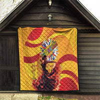 Yellow quilt with red spiral swirls and a central round emblem, quilted diamond pattern