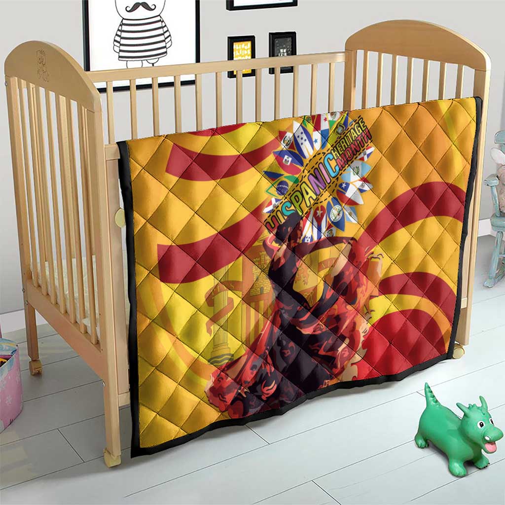 Yellow quilt with red spiral swirls and central emblem, draped in baby crib