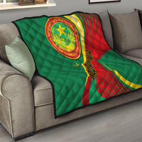 Mauritania quilt blanket on gray sofa, green quilted fabric with red yellow emblem