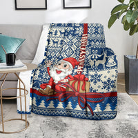 Blue throw blanket featuring Santa holding a gift, navy and white fair isle design
