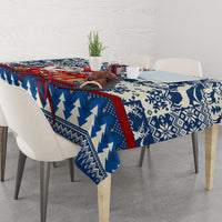 Blue holiday tablecloth with snowflake and reindeer motif, red border stripe