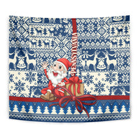 Blue rectangular tapestry close-up: Santa in red holding a gift, surrounded by winter icons and stripes