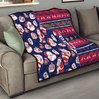 Blue Christmas quilt folded on sofa with Santa, gift icons, and red navy zigzag design