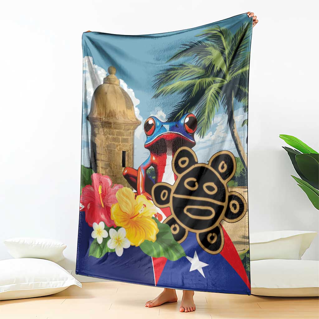 Blue blanket draped over couch showing El Morro tower, coqui frog, palms, flowers and star