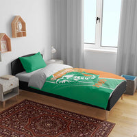 Green and orange Cote d'Ivoire elephant duvet with two green pillowcases on bed